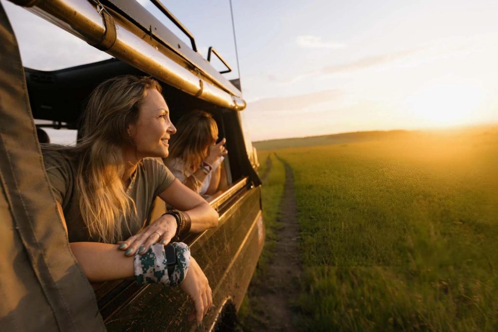 First-time safari tourists enjoying a sunset game drive in Kenya.